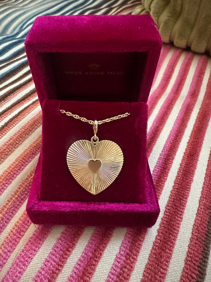 Amami Charm, Gold heart-shaped pendant necklace in a jewelry box.  