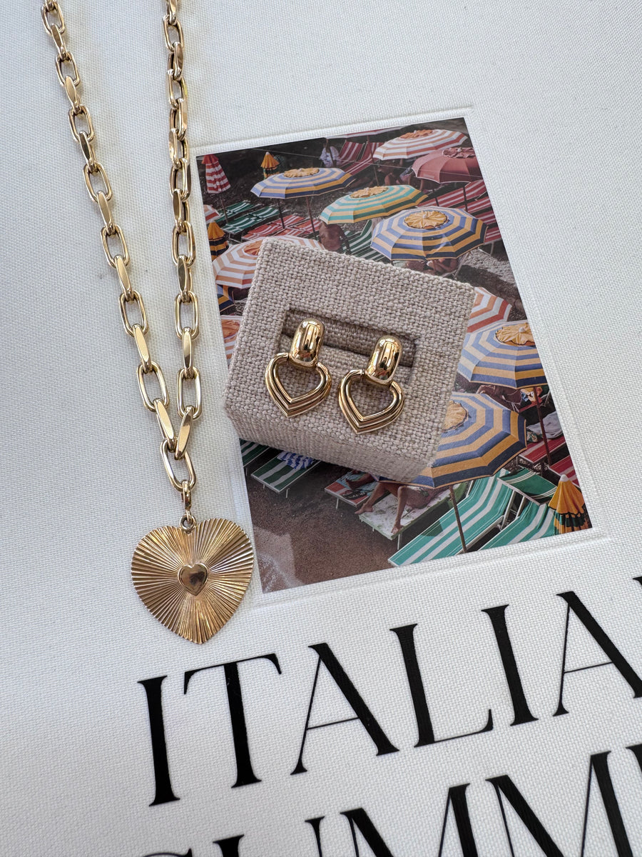 Gold necklace with a pendant on a magazine with a patterned cover